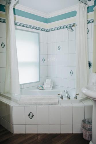 a white bathroom with a tub and a sink at Benn Conger Inn in Groton