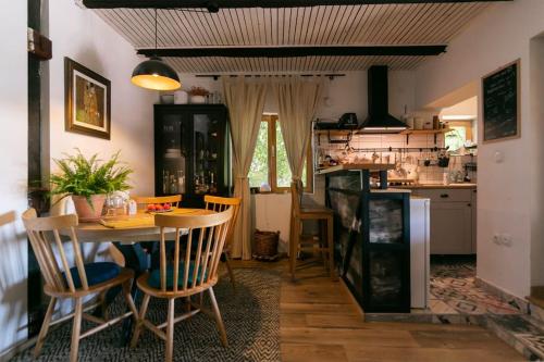 uma cozinha e sala de jantar com mesa e cadeiras em Cottage Veronika em Velika Gorica