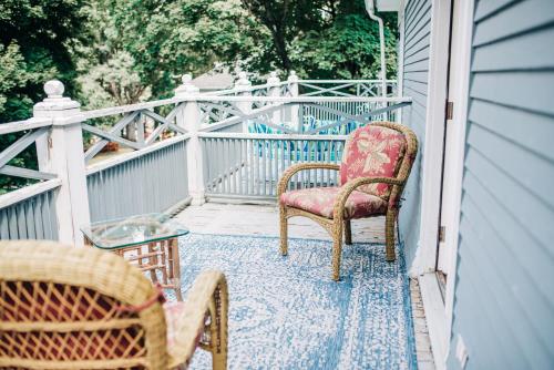 a porch with two chairs and a table and a fence at Benn Conger Inn in Groton
