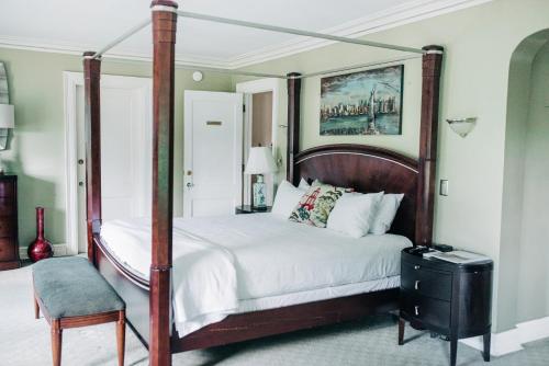 a bedroom with a four poster bed and a chair at Benn Conger Inn in Groton