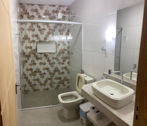 a bathroom with a toilet and a sink and a shower at Pousada Pedra Encantada in São Thomé das Letras