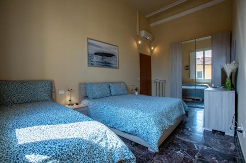 a bedroom with two beds and a mirror at Florence Urban Nest ~ Guesthouse in Florence