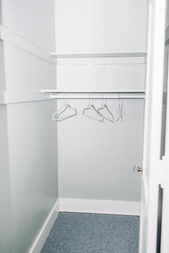 a walk in closet with white walls and hangers at Benn Conger Inn in Groton