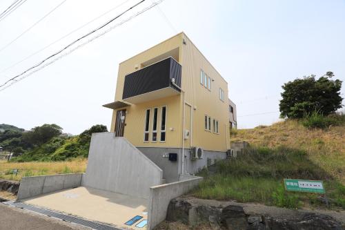 a yellow house on top of a hill at 白浜パークサイドヴィラ(G-79) in Shirahama