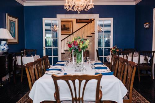 a dining room with a table with flowers on it at Benn Conger Inn in Groton