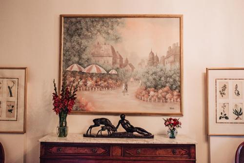 a painting on a wall above a table with flowers at Benn Conger Inn in Groton