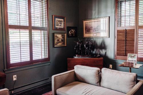 a living room with a couch and two windows at Benn Conger Inn in Groton