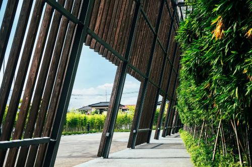 a wooden fence next to a sidewalk next to a street at Garden Terrace Saga Hotel & Resorts in Saga