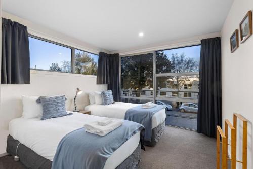 1 dormitorio con 2 camas y ventana grande en Mountain View en Queenstown
