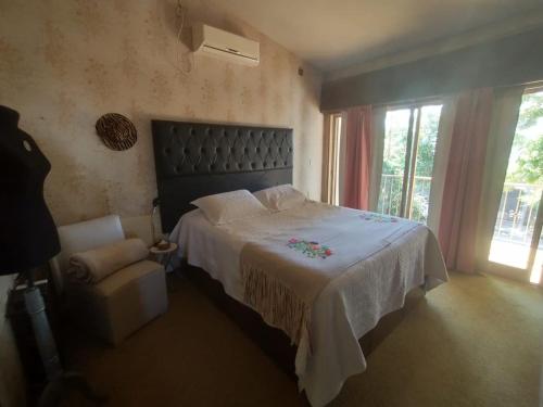1 dormitorio con 1 cama grande y 1 silla en Casa Carlos Paz en Villa Carlos Paz