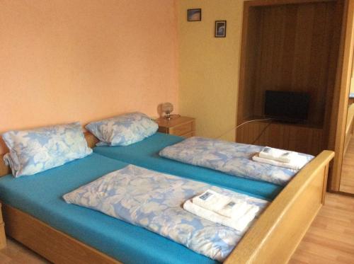 two beds in a room with blue sheets and towels at Hotel Drei Könige in Neckarbischofsheim