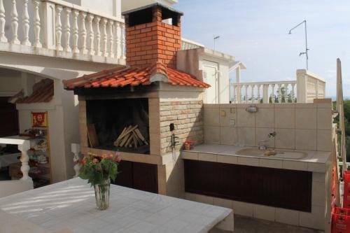 a outdoor kitchen with a fireplace and a table at Apartments with a parking space Rukavac, Vis - 8838 in Vis