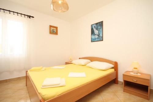 a bedroom with a bed with yellow sheets and white pillows at Apartments with a parking space Rukavac, Vis - 8838 in Vis