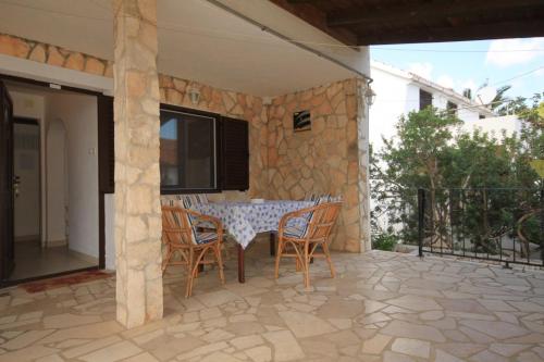 a patio with a table and chairs and a television at Apartments with a parking space Rukavac, Vis - 8848 in Rukavac