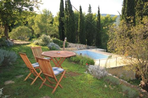 einen Tisch und Stühle in einem Garten mit Pool in der Unterkunft Family friendly house with a swimming pool Talez, Vis - 8850 in Vis