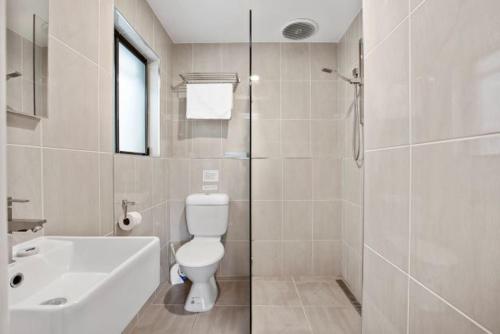 a bathroom with a toilet and a sink and a shower at Byron Bay Accom Unit 6 70 Lawson Street - Atlantis in Byron Bay