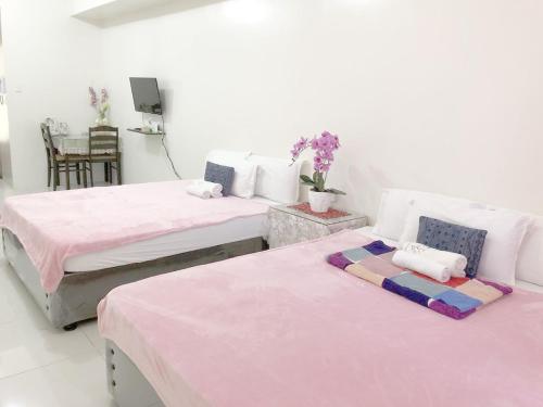 two beds in a white room with pink sheets at SMDC Tagaytay Taal Lake Condo Cook Netflix No Balcony No Free Parking Contact to Confirm in Tagaytay