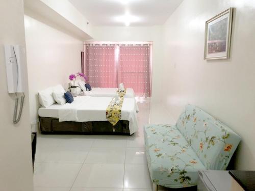 a white bedroom with a bed and a chair at SMDC Tagaytay Taal Lake Condo Cook Netflix No Balcony No Free Parking Contact to Confirm in Tagaytay