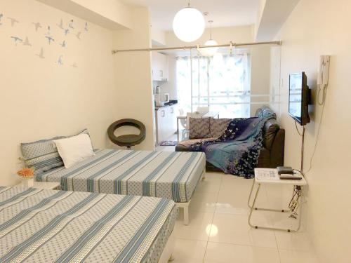 a living room with two beds and a couch at SMDC Tagaytay Taal Lake Condo Cook Netflix No Balcony No Free Parking Contact to Confirm in Tagaytay