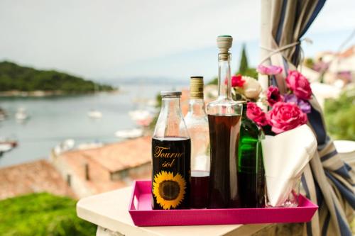 ein Tablett mit 2 Flaschen Wein und Blumen in der Unterkunft Apartments by the sea Stomorska, Solta - 8650 in Stomorska