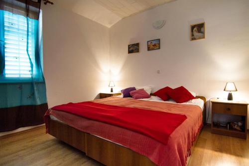 a bedroom with a large bed with red pillows at Apartments by the sea Stomorska, Solta - 8650 in Stomorska