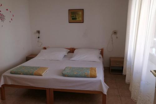 a bedroom with a bed with two pillows on it at Apartments and rooms by the sea Komiza, Vis - 8841 in Komiža