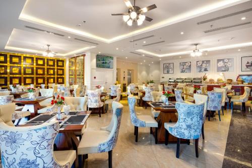 un restaurante con mesas y sillas azules y blancas en Menora Grand Da Nang, en Da Nang
