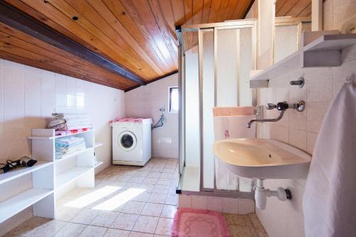 a bathroom with a sink and a washing machine at Apartments and rooms with parking space Komiza, Vis - 8844 in Komiža