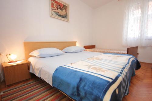 a bedroom with a bed with a blue and white blanket at Apartments by the sea Vis - 8534 in Vis