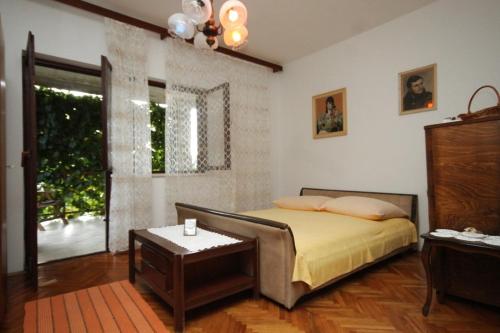 a bedroom with a bed and a table and a window at Apartments with a parking space Vis - 8861 in Vis