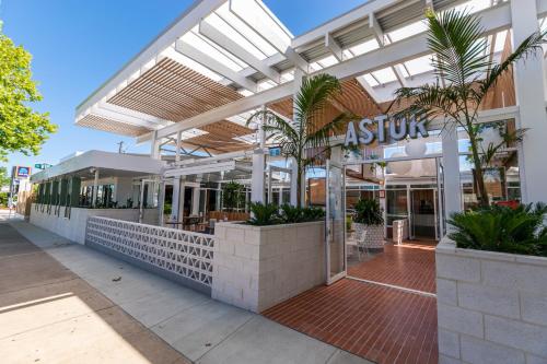 a store front of a shopping center with palm trees at Astor Hotel Motel in Albury