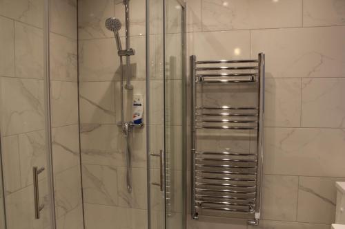 um chuveiro numa casa de banho com uma porta de vidro em Cosy Central Luton Studio Flat -Ideal for Airport! em Luton