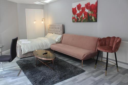 uma sala de estar com um sofá e uma cama em Cosy Central Luton Studio Flat -Ideal for Airport! em Luton
