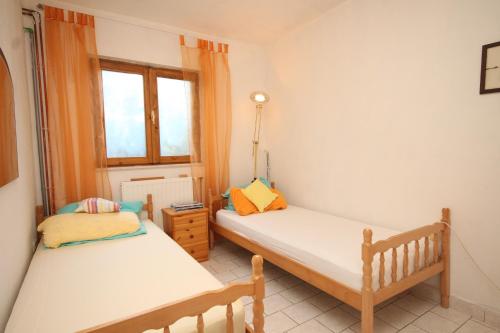 a bedroom with two beds and a window at Apartments with a parking space Rukavac, Vis - 8864 in Rukavac