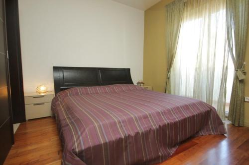 a bedroom with a bed with a purple comforter and a window at Apartments by the sea Split - 8671 in Split