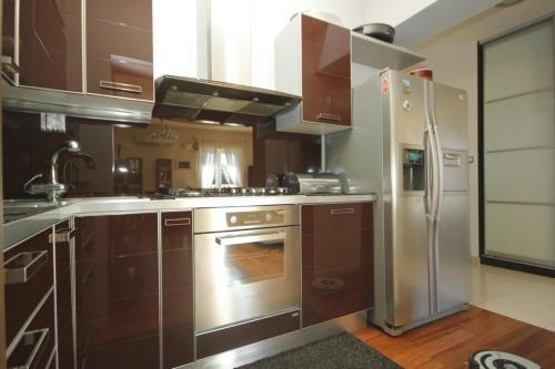 a kitchen with brown cabinets and a stainless steel refrigerator at Apartments by the sea Split - 8671 in Split
