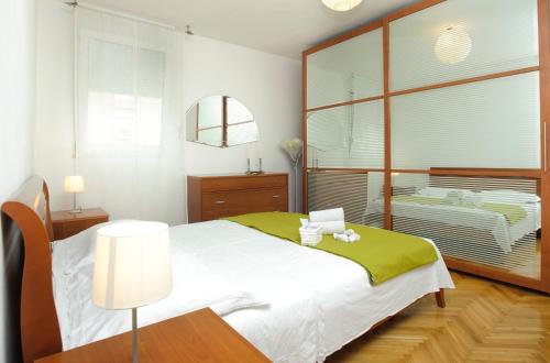 a bedroom with a bed and a table with a lamp at Apartments with a parking space Split - 8681 in Split