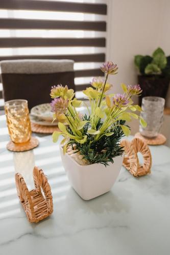 a white vase with flowers on a table at Amplio, hermoso, cómodo depa en Mazatlán in Mazatlán