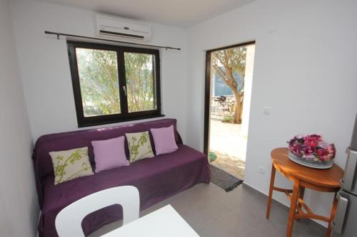 ein Zimmer mit einem lila Sofa und einem Tisch in der Unterkunft Apartments by the sea Rogac, Solta - 8688 in Grohote