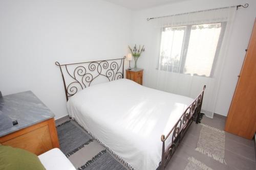 ein Schlafzimmer mit einem weißen Bett und einem Fenster in der Unterkunft Apartments by the sea Rogac, Solta - 8688 in Grohote