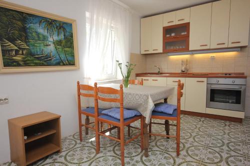 a kitchen with a table and two chairs and a table at Apartments by the sea Necujam, Solta - 8691 in Nečujam