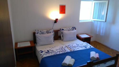 a small bedroom with a blue and white bed with pillows at Apartments with a parking space Rukavac, Vis - 8863 in Rukavac