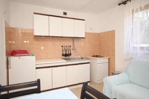 a kitchen with white cabinets and a white refrigerator at Apartments with a parking space Rukavac, Vis - 8863 in Rukavac