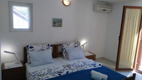 a bedroom with a blue and white bed and a window at Studio Rukavac 8863a in Rukavac