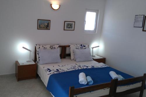 a bedroom with a bed with blue sheets and pillows at Apartment Rukavac 8863c in Rukavac