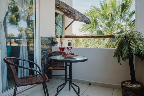 una mesa con 2 copas de vino en el balcón en Punta Esmeralda I, en Altata