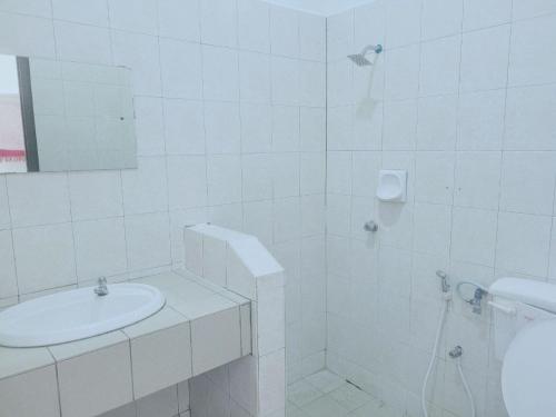 PendangにあるDeluxe Roomの白いバスルーム(シンク、シャワー付)