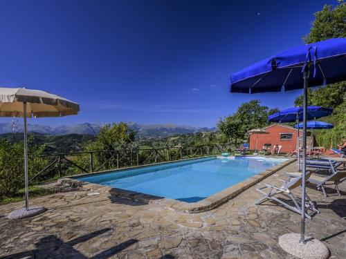 Monte San MartinoにあるSplendid Apartment with Pool near Sibillini Mountainsのスイミングプール(パラソル2つ、椅子2脚付)