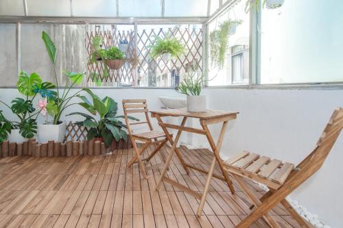 a table and chairs in a room with plants at Purple Flower House in Tainan