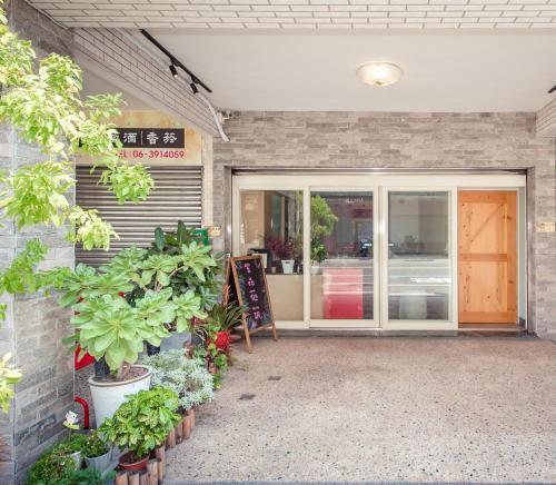 a front door of a store with plants at 紫品花筑Purple Flower House in Anping